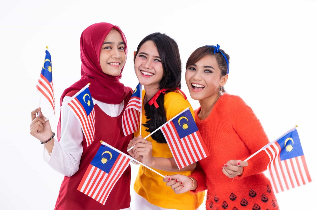 people holding malaysia flag celebrating independence day min scaled